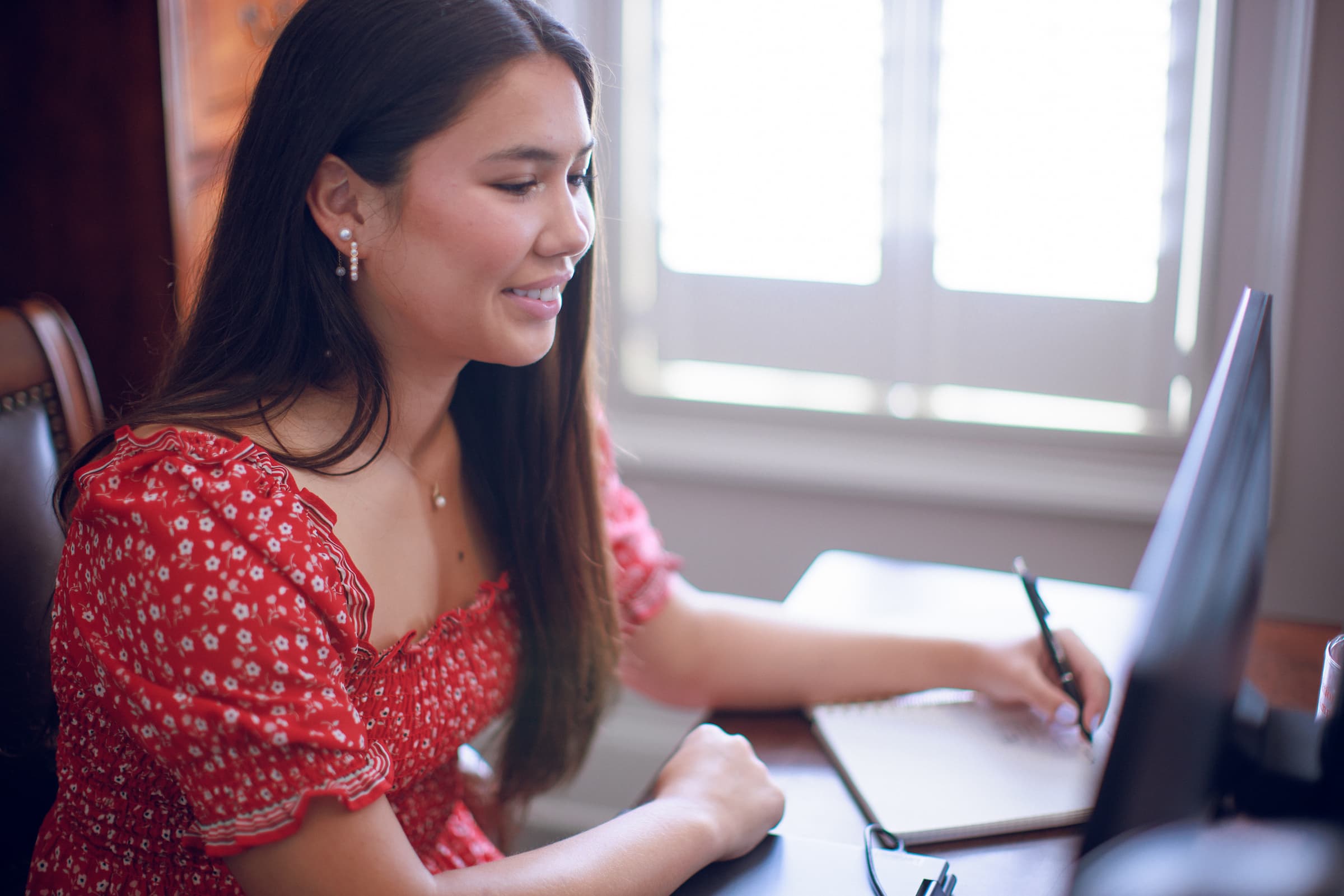 Girl sitting at computer taking notes