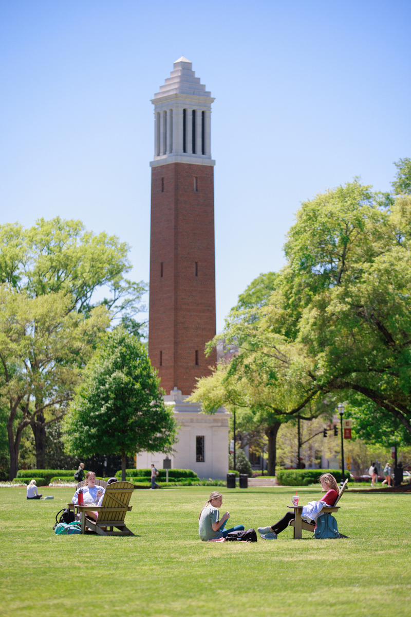 Students relax on the Quad with Denny Chimes in the background at The University of Alabama.