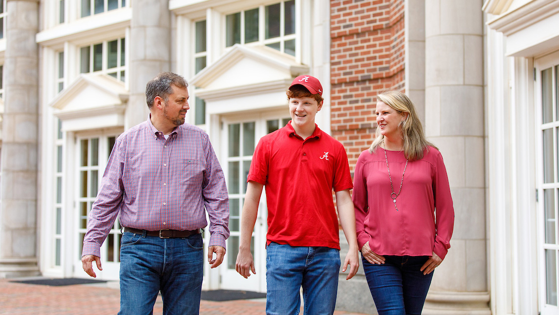 Student walking with his parents outside Shelby Hall